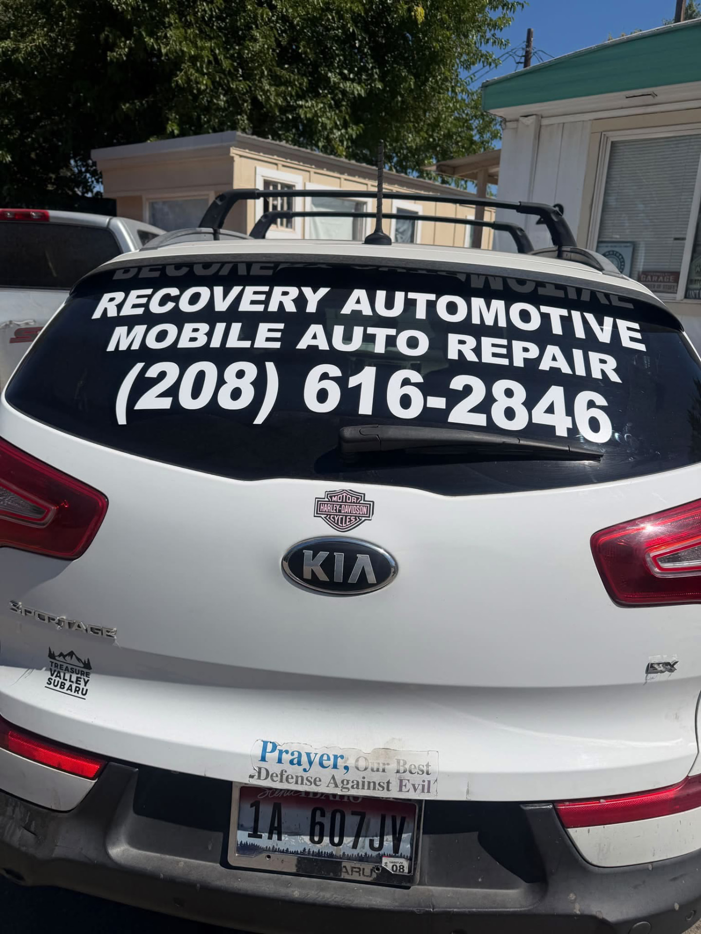 Recovery Automotive service vehicle with the business name and phone number lettered on the rear window