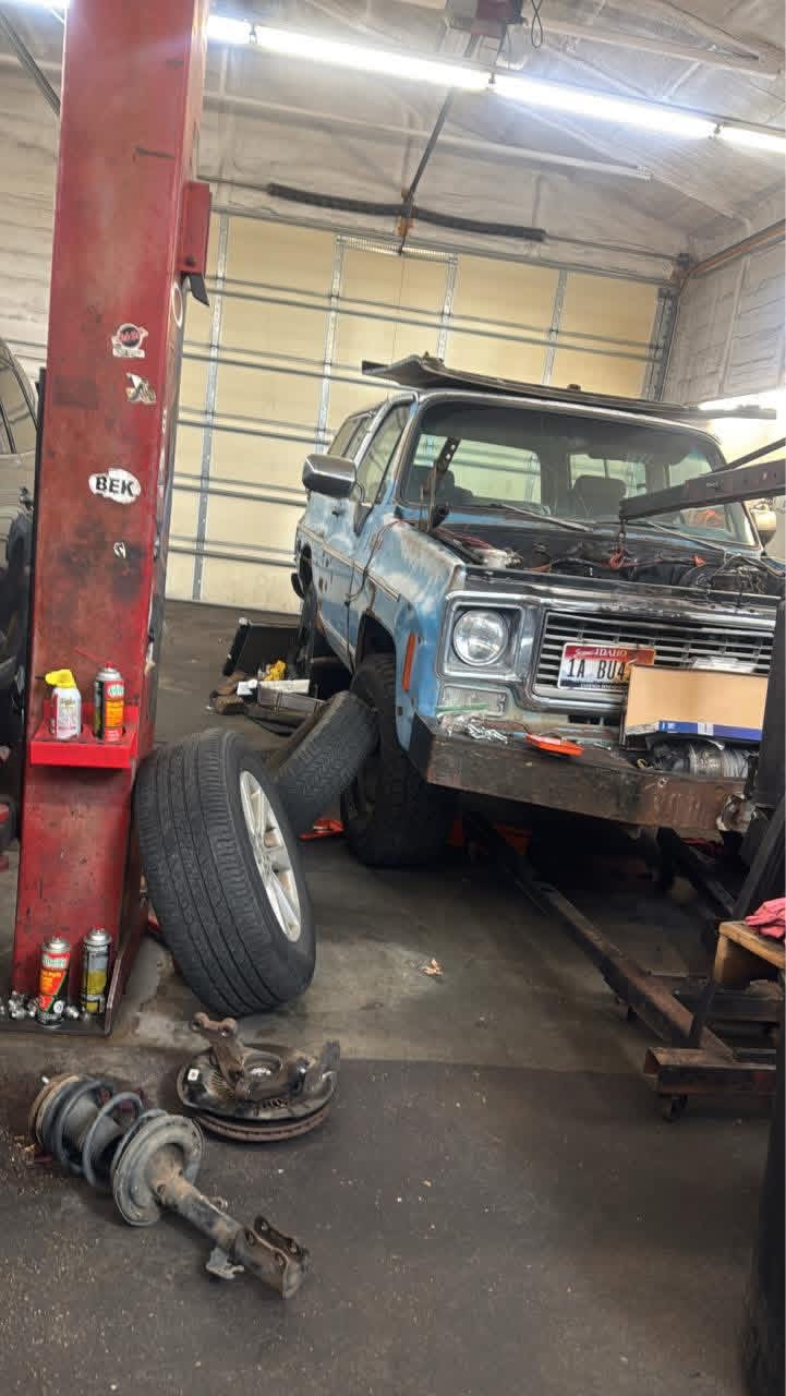 Pickup truck raised on a lift with suspension and hub components removed