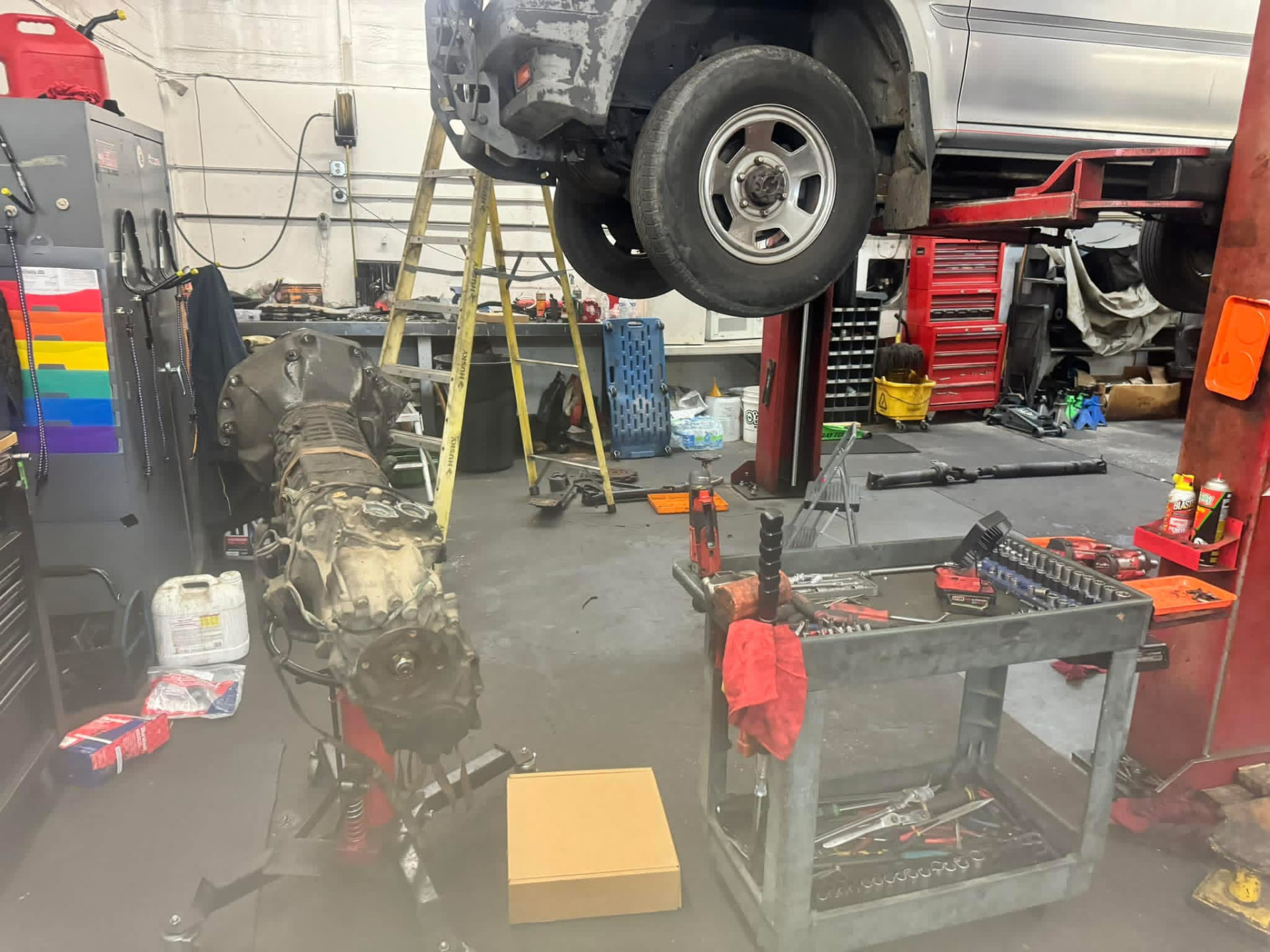Transmission removed and vehicle on a lift during a Recovery Automotive repair